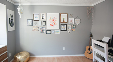 Newly painted wall with several pieces of framed artwork