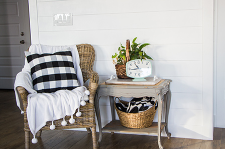 Wicker chair and site table in front of the finished shiplap wall