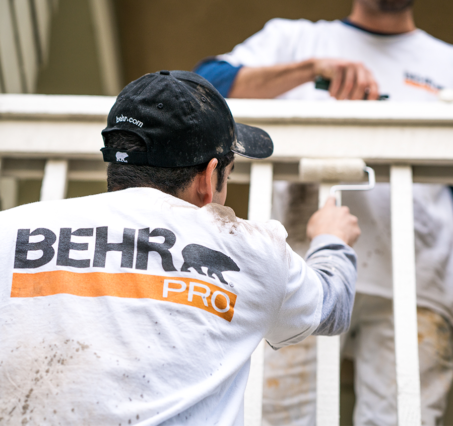 Small image of 2 Pro painters painting the wooden railings of the exterior of an apartment block