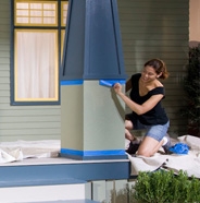 Image of lady removing painter's tape from house exterior