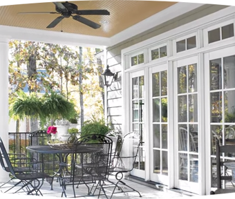 Outdoor patio area with a table, chairs, and a ceiling fan