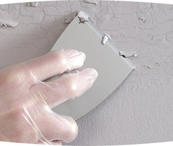 Person repairing peeling paint on wall