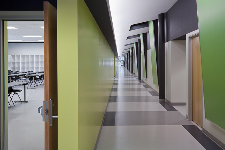 An image of a small empty classroom hallway with a green, gray and white color combination.