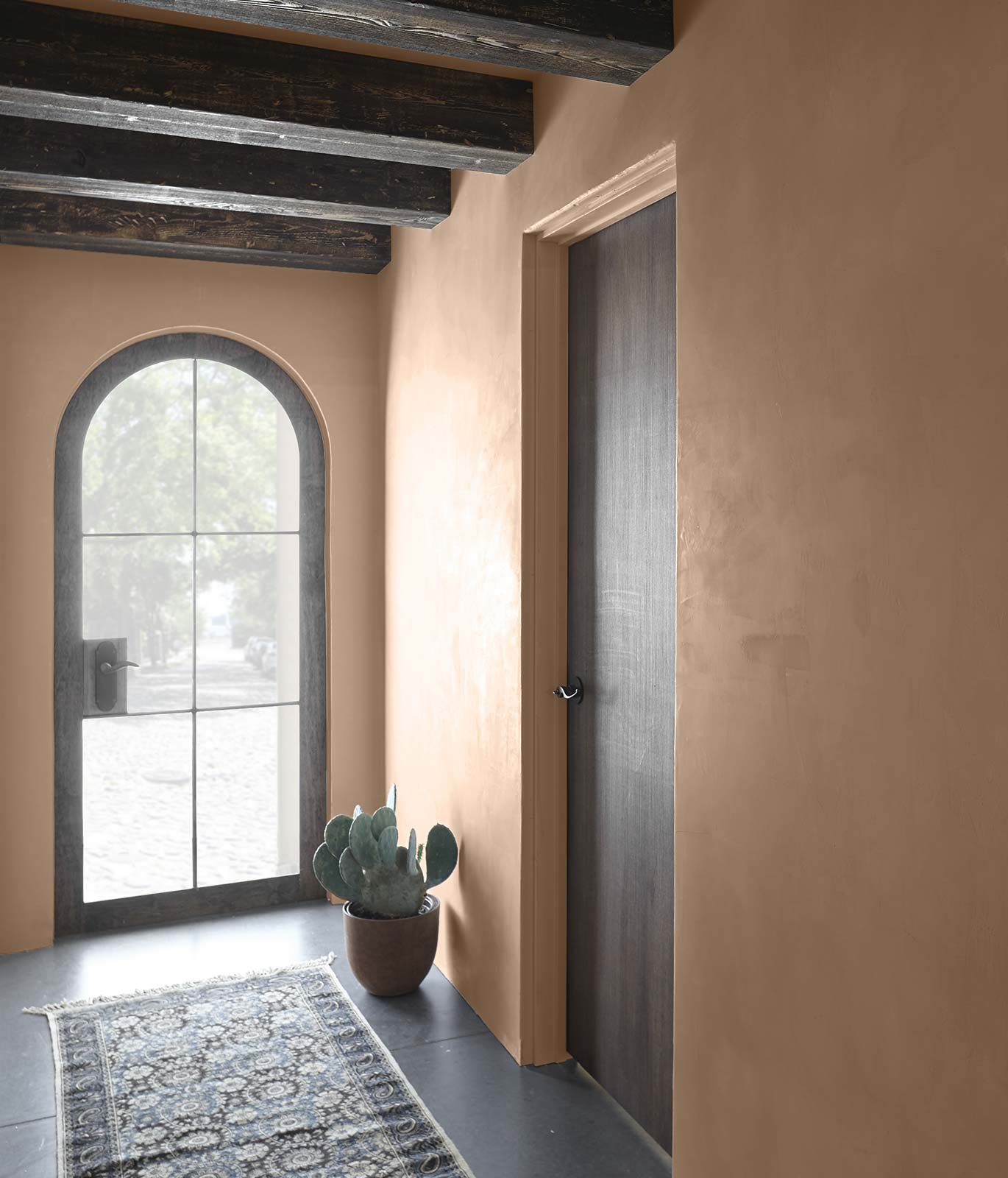 A comforting entry way with warm tan painted walls and dark brown colored wood trim. 