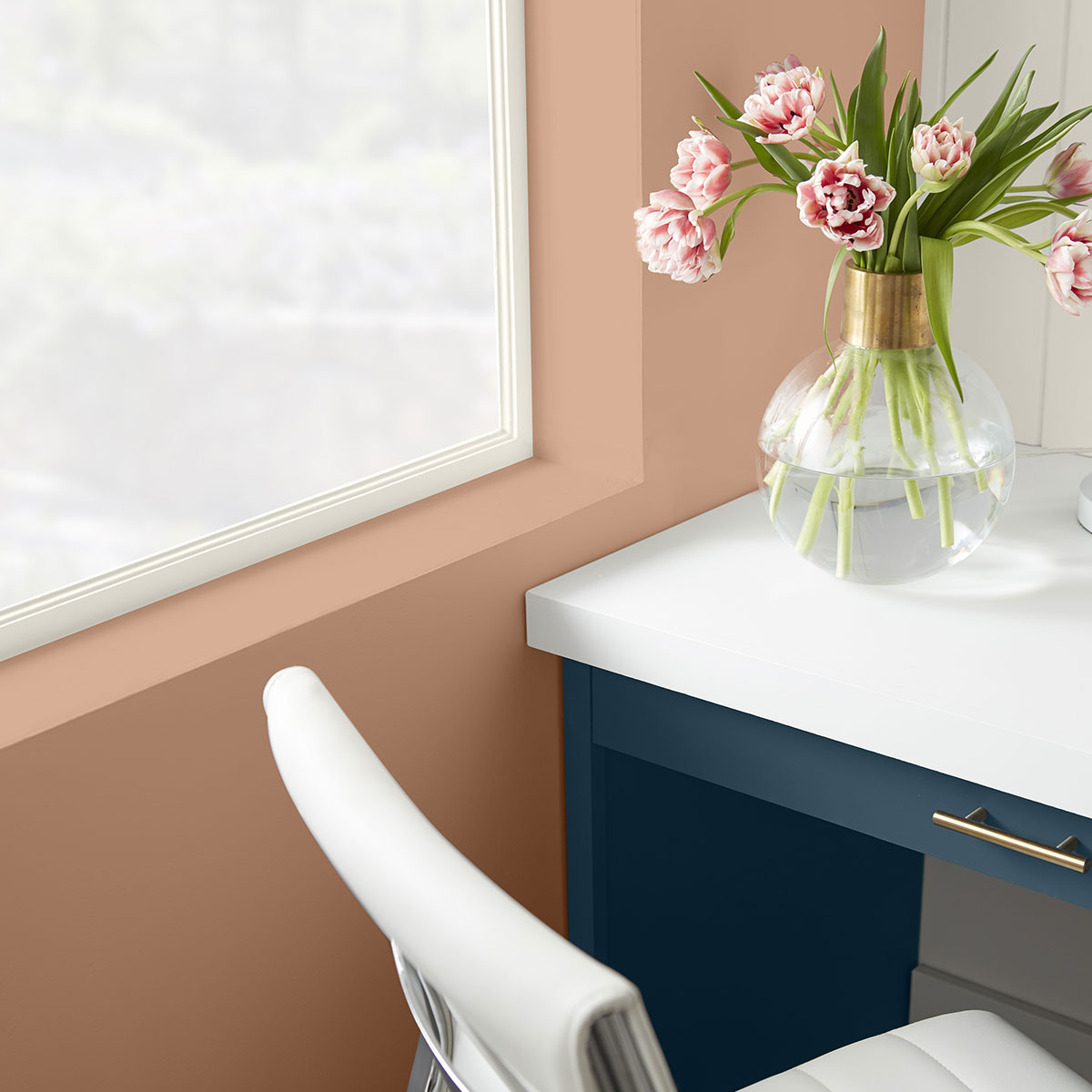 A corner of a desk with blue drawers and a white top. The wall that sits to the right is painted in Canyon Dusk.