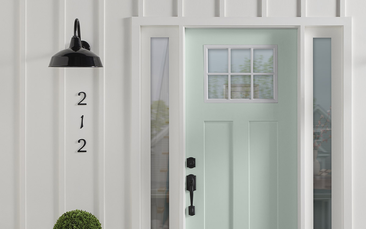 A front door painted in a soft sea glass green hue.