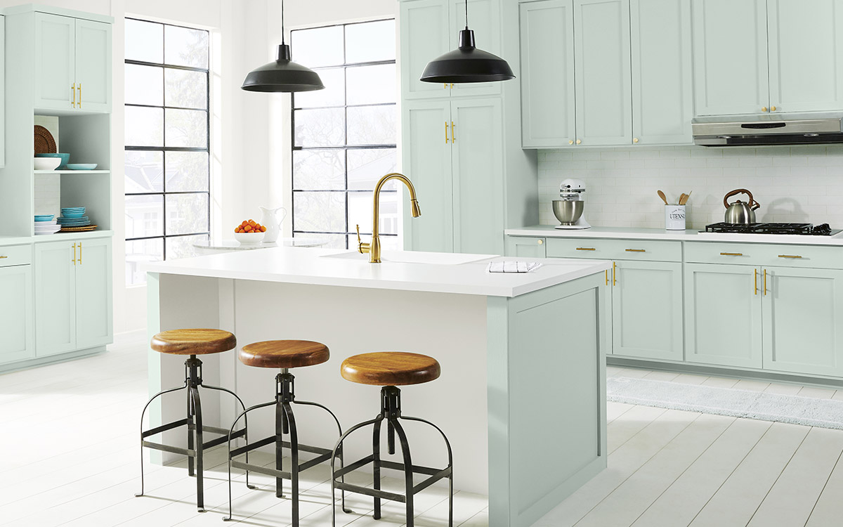 A kitchen with the cabinets painted in a soft sea glass green color.